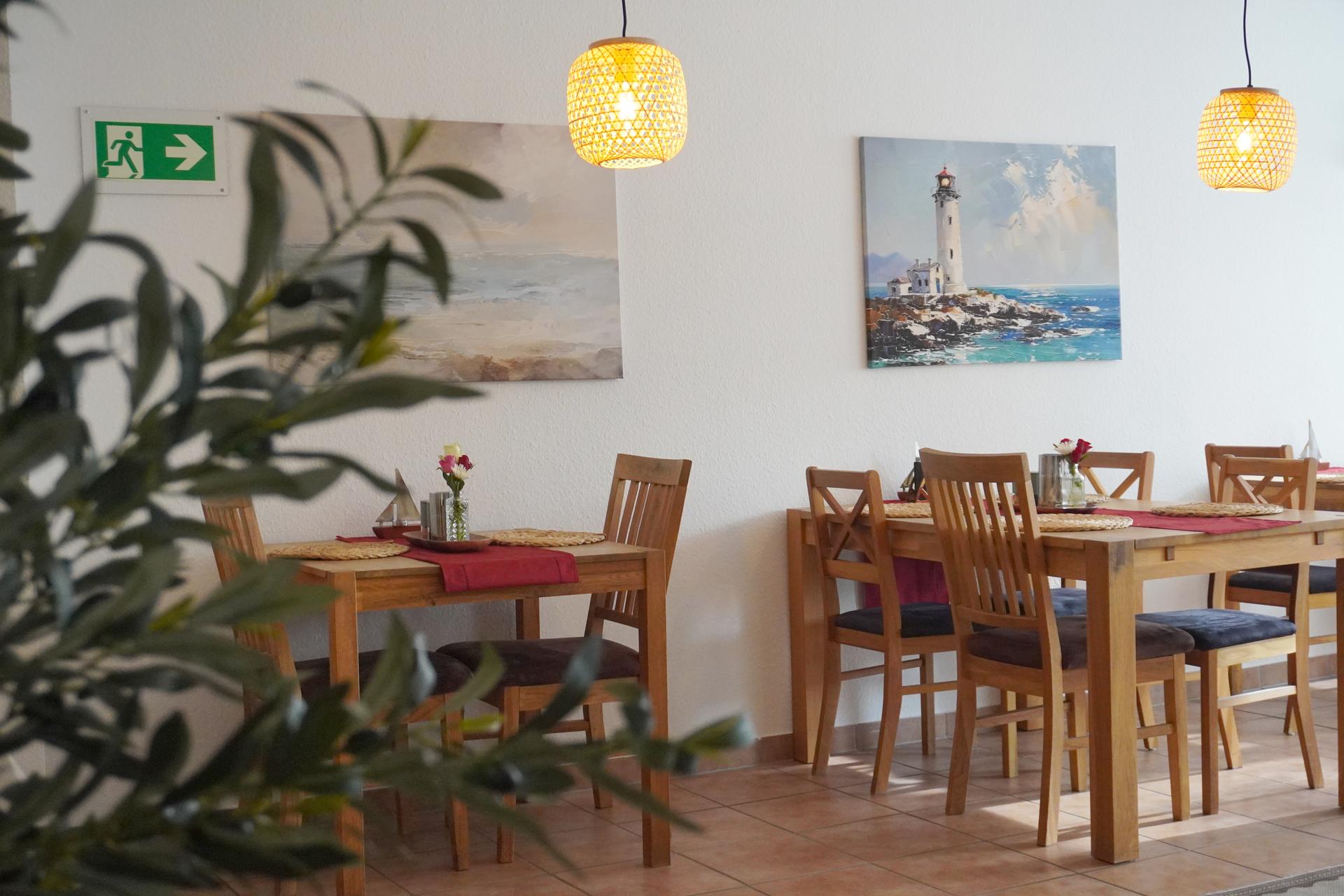 Frühstücksraum mit Tischen und Pflanzen der Pension ElbKate in Glückstadt