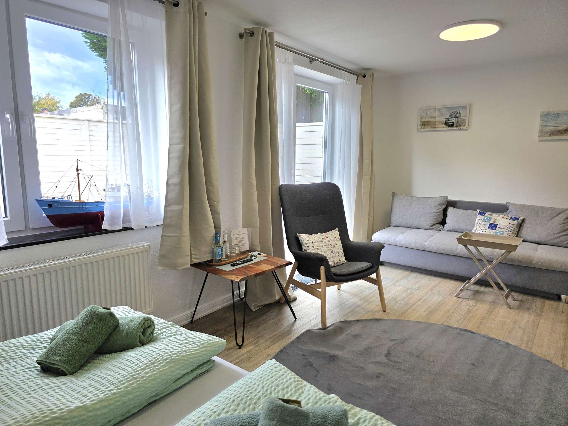 Sitzecke mit Sofa und Sessel im Zimmer Backbord der Pension ElbKate in Glückstadt