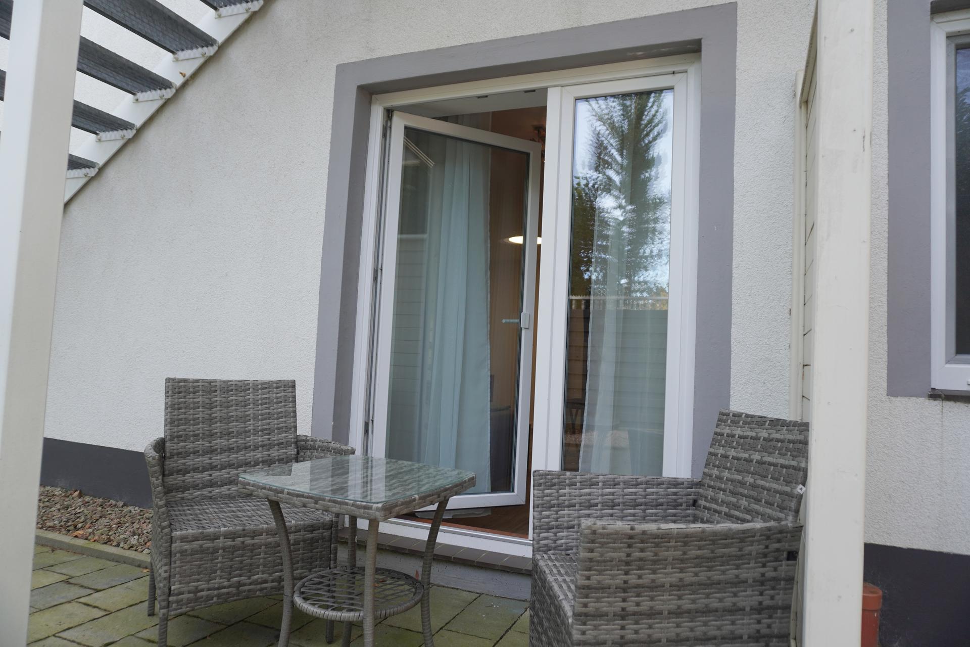 Terrasse mit Sitzgruppe vor einem Zimmer im Erdgeschoss der Pension ElbKate in Glückstadt