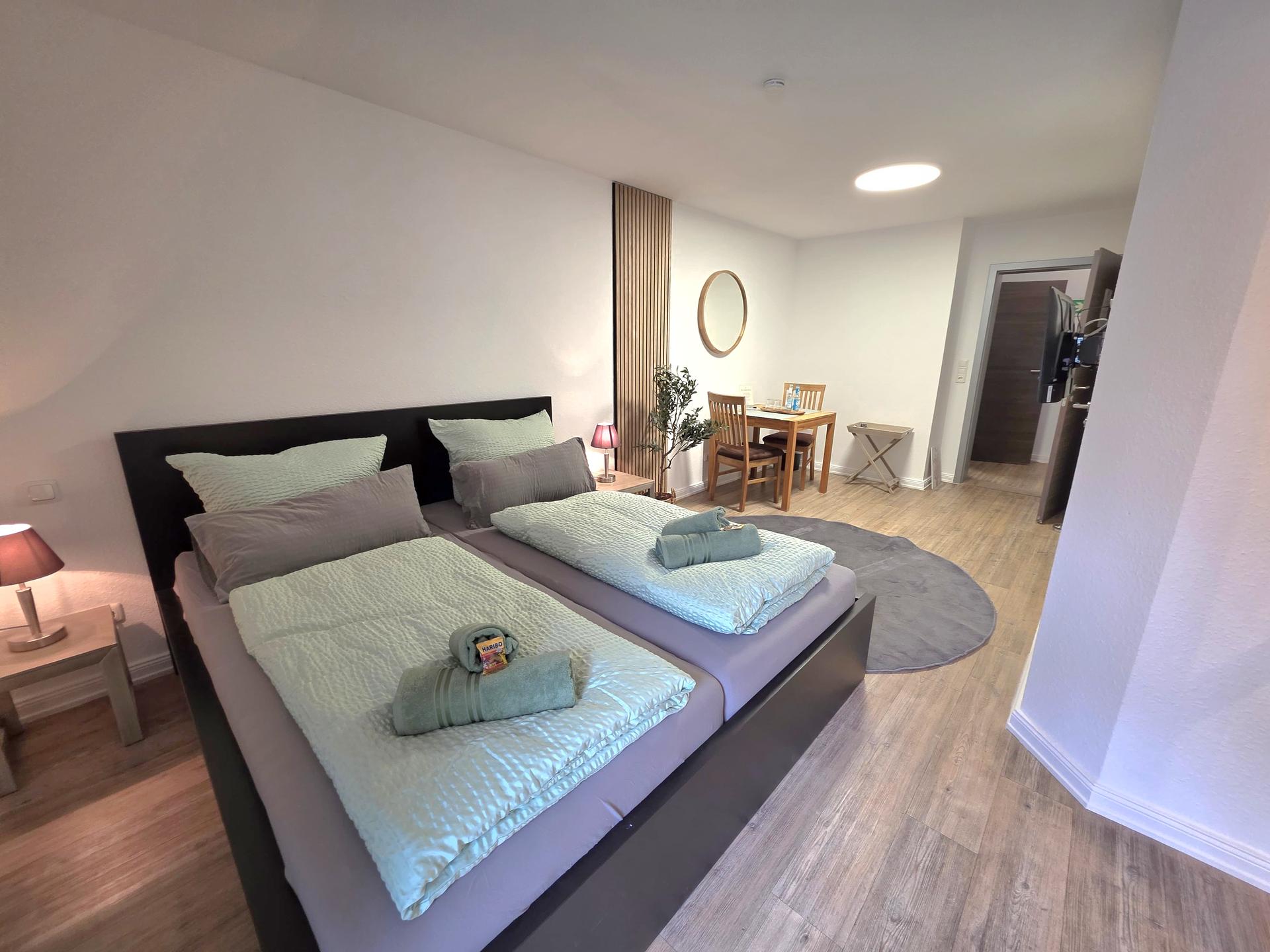 Doppelbett mit Schreibtisch im Zimmer Hafenruhe der Pension ElbKate in Glückstadt