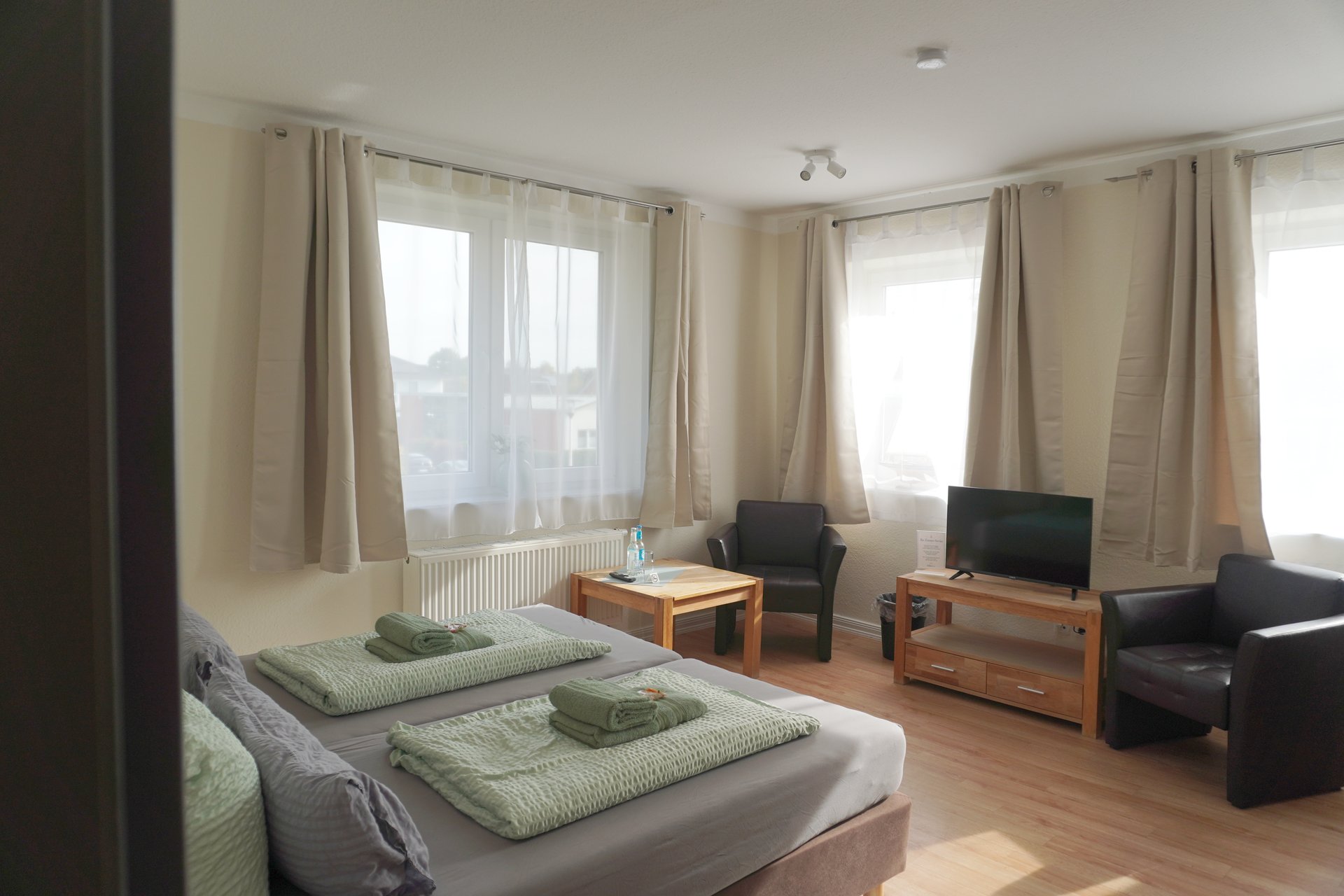 Betten und Sitzecke im Zimmer Heimathafen der Pension ElbKate in Glückstadt