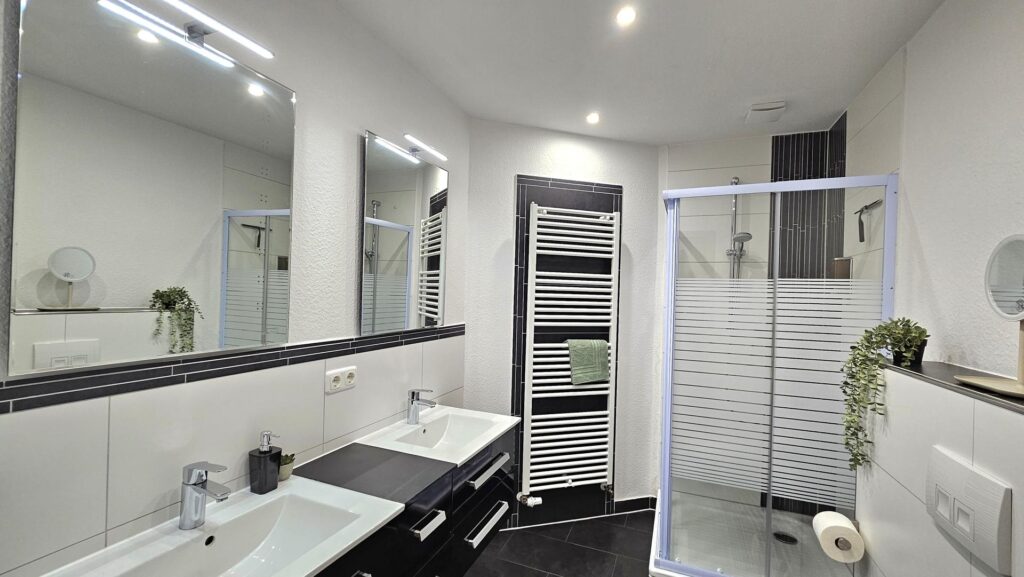 Bad mit Waschtisch und Dusche im Zimmer Küstenruhe der Pension ElbKate in Glückstadt