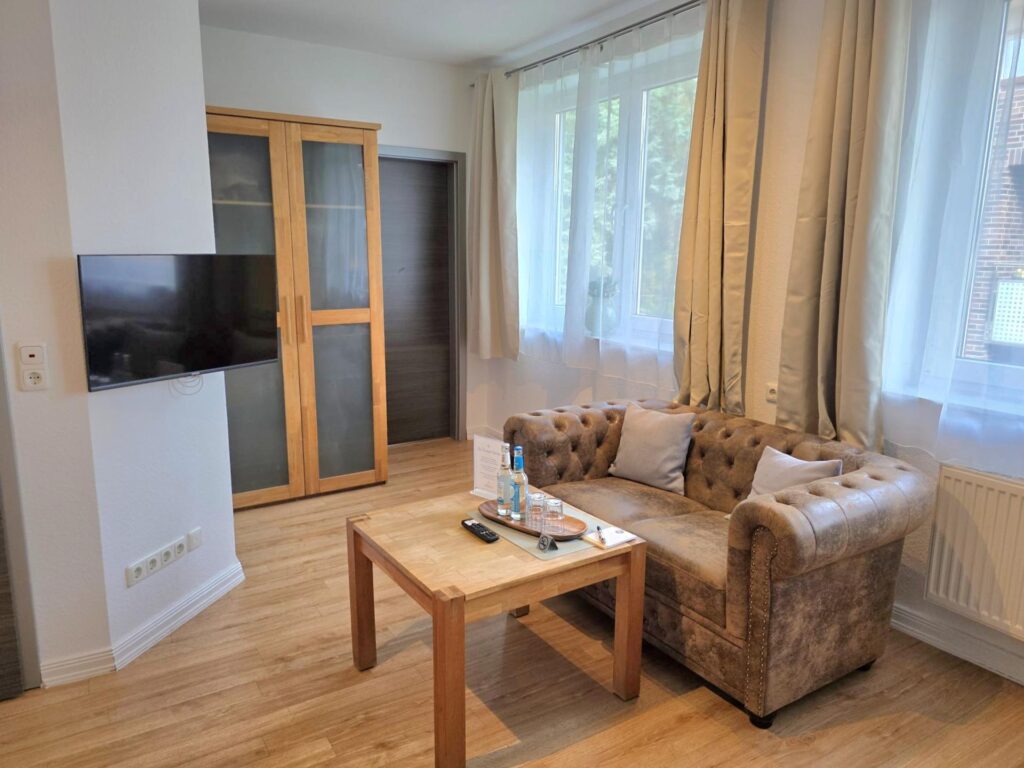 Sitzecke mit Sofa und Couchtisch im Zimmer Küstenruhe der Pension ElbKate in Glückstadt